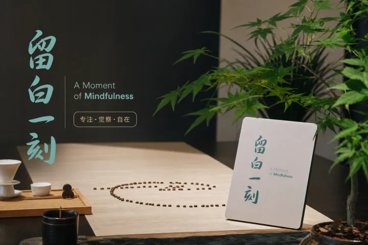木桌上展示正念冥想用品,包括念珠、书籍、茶杯和绿色植物